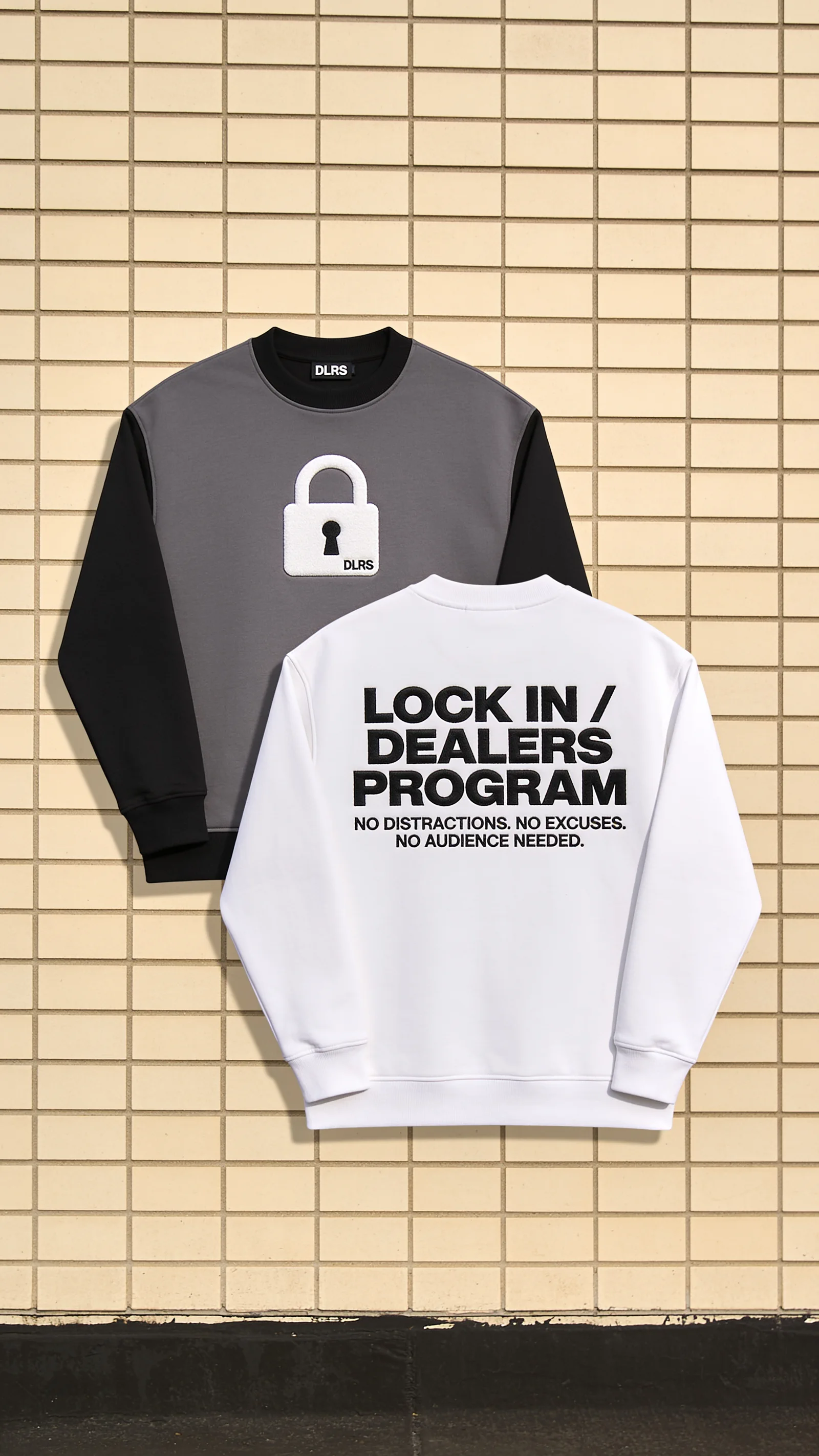 Gray and white Dealers Program sweatshirts against a tiled wall